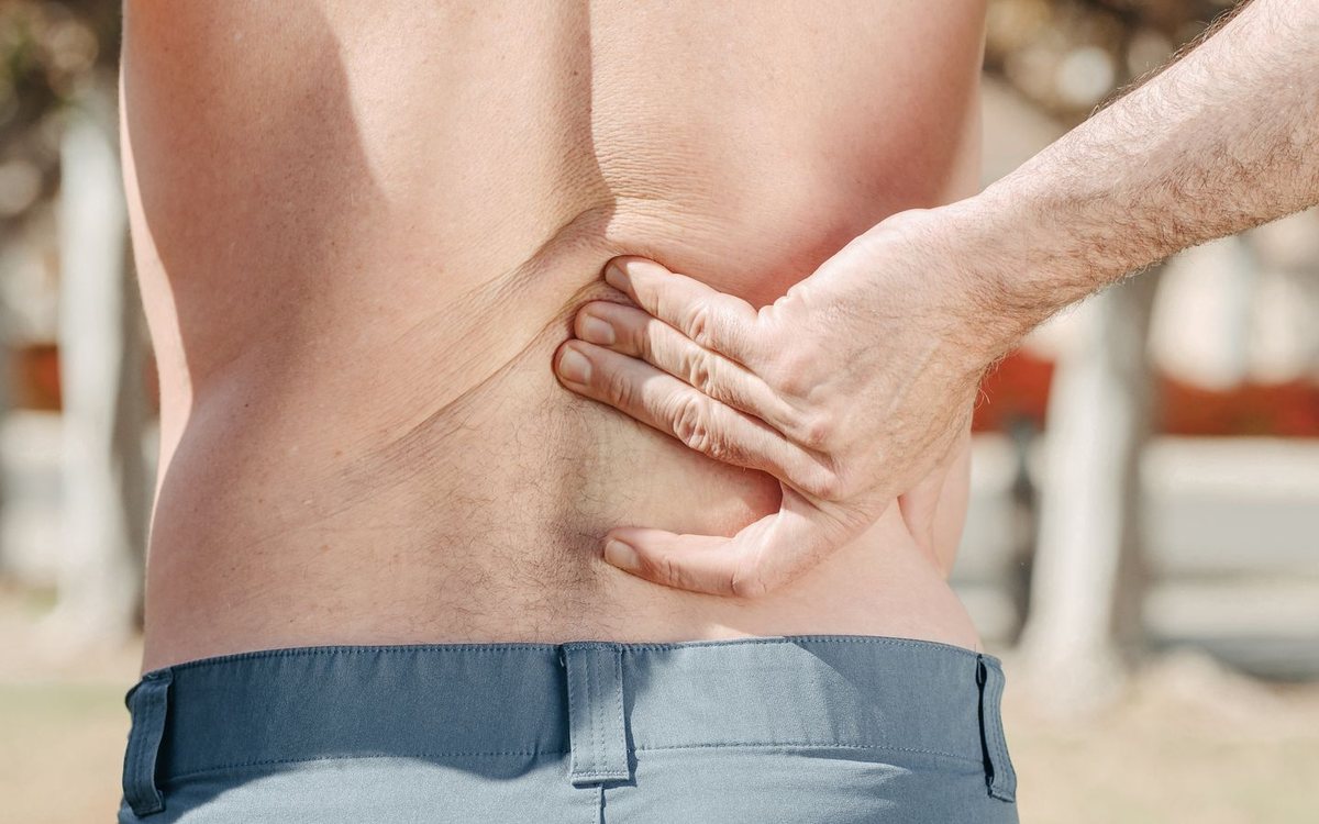 A man holding his lower back in pain