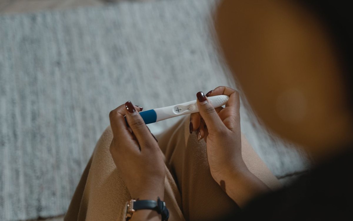 A woman holding a positive pregnancy test