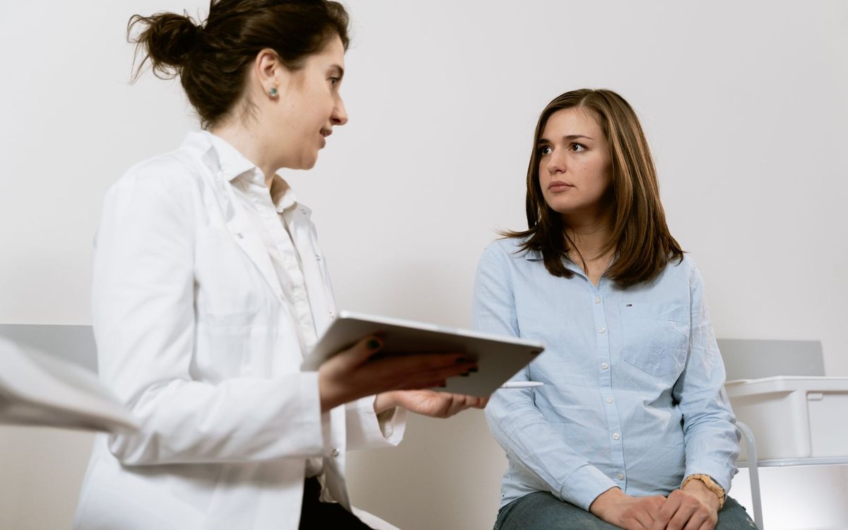 A doctor consulting a pregnant patient in a clinic