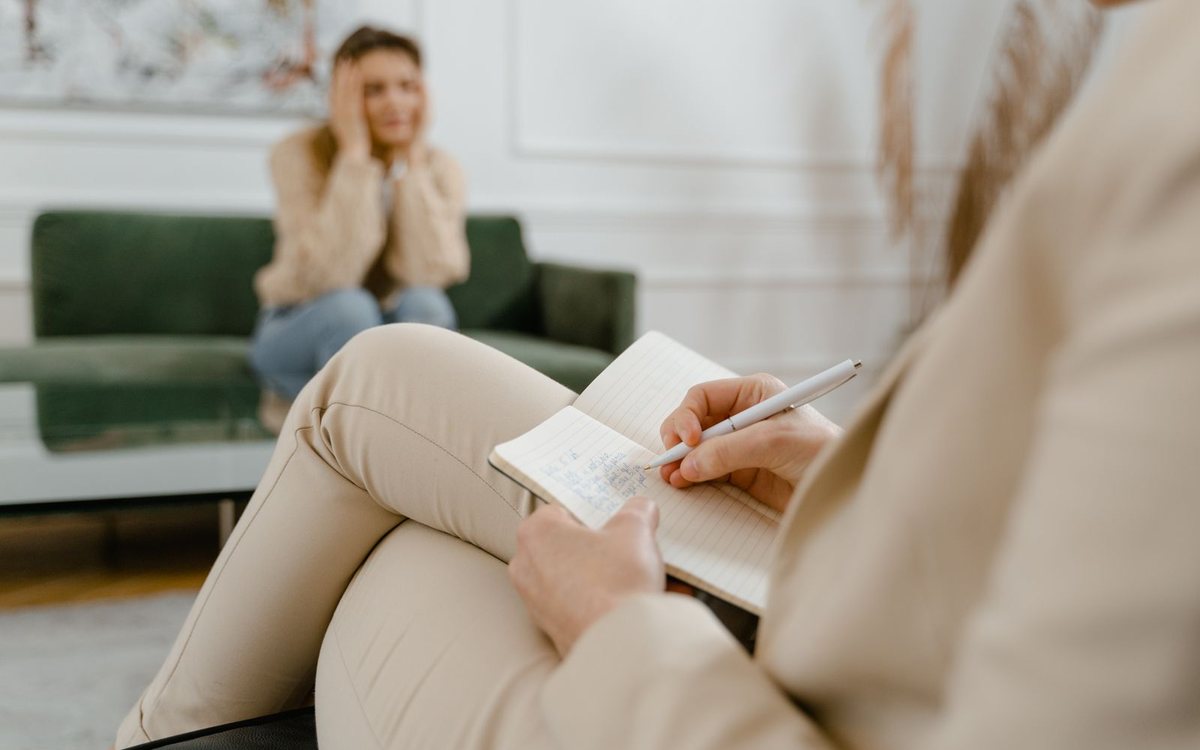 A therapist taking notes during a mental health consultation