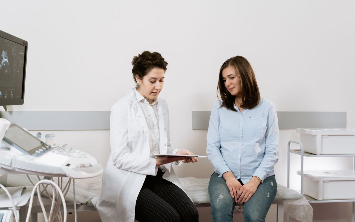A pregnant woman consulting with her gynecologist in a clinic
